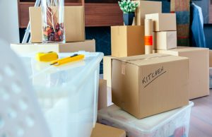 Packed-up belongings in cardboard boxes and plastic bins